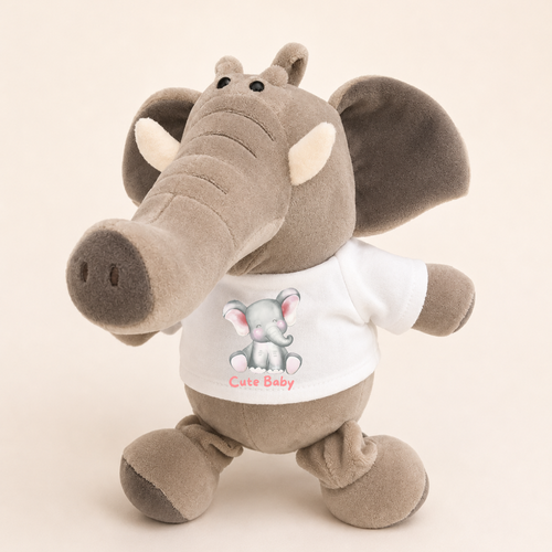 A plush elephant toy wearing a white T-shirt with a baby elephant graphic and the words 'Cute Baby' in pink, photographed against a plain light beige background.