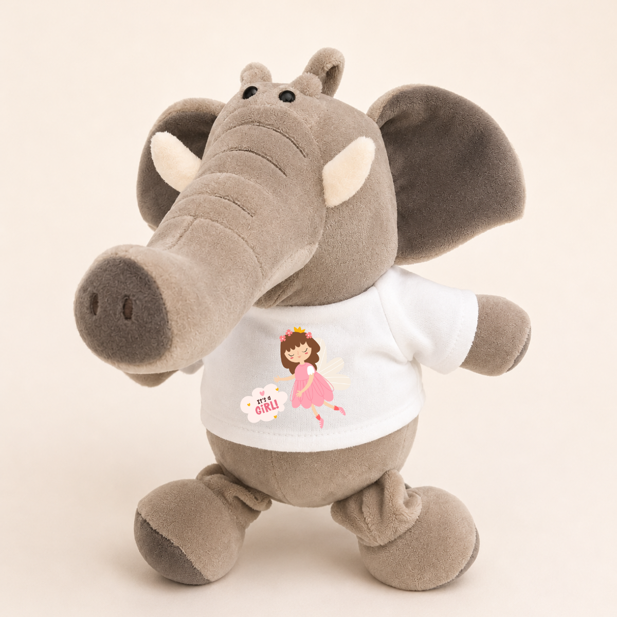 A plush elephant toy in soft gray fabric wearing a white T-shirt with a pink fairy graphic and the words 'elephant girl'.