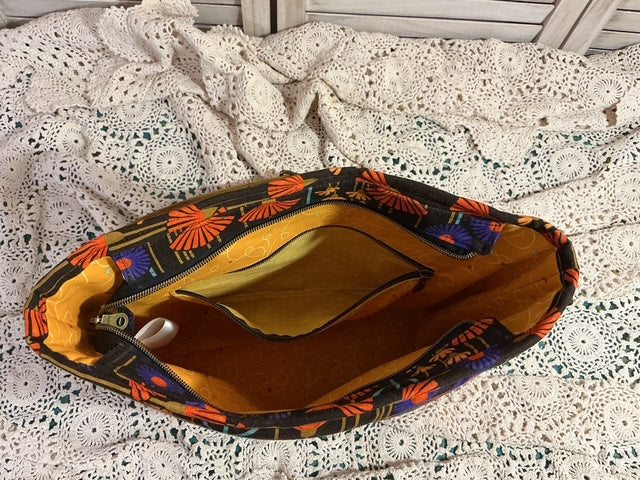 Colorful handbag with floral pattern on a textured white surface