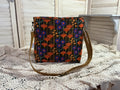Floral patterned bag on a textured surface with a neutral background