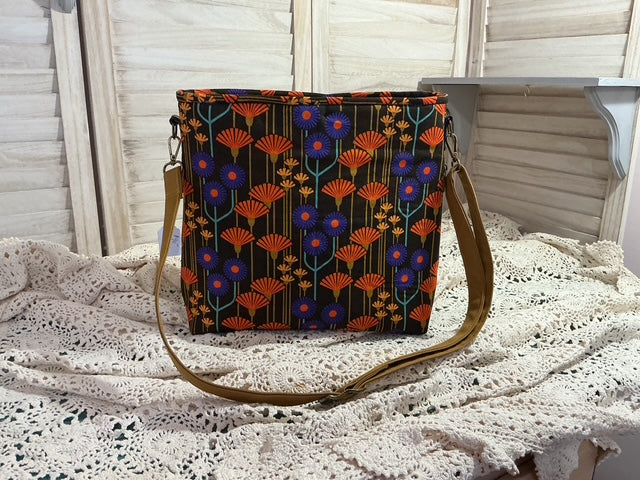 Floral patterned bag on a textured surface with a neutral background