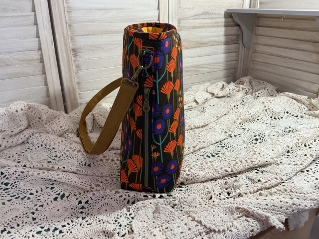 Decorative wine bottle bag with floral pattern on a textured surface