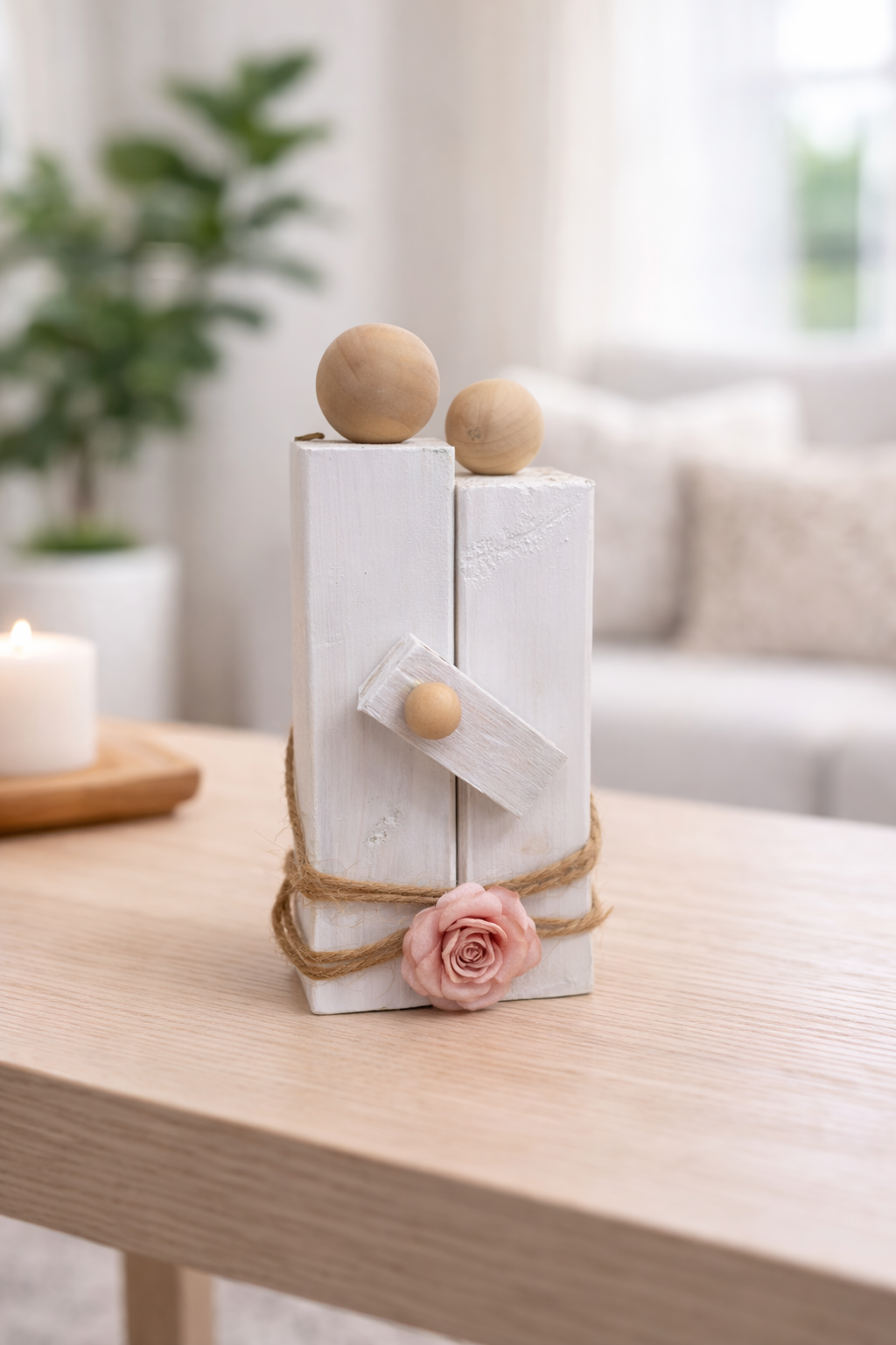 Decorative item with wooden spheres and a pink flower on a table in a living room setting.