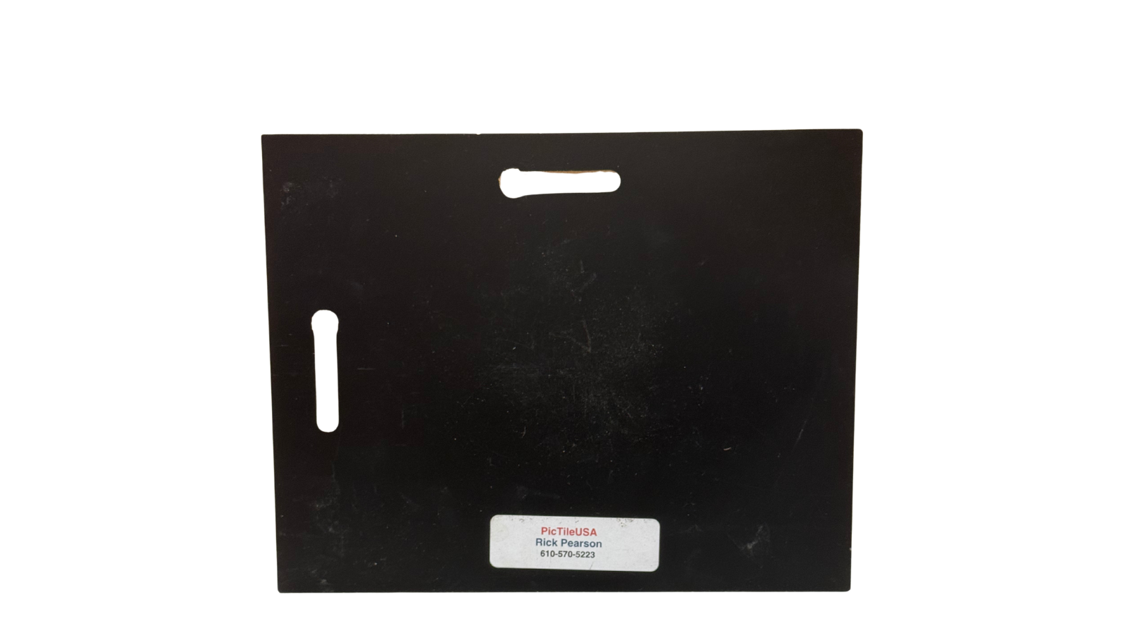Black rectangular object with cutouts on a white background