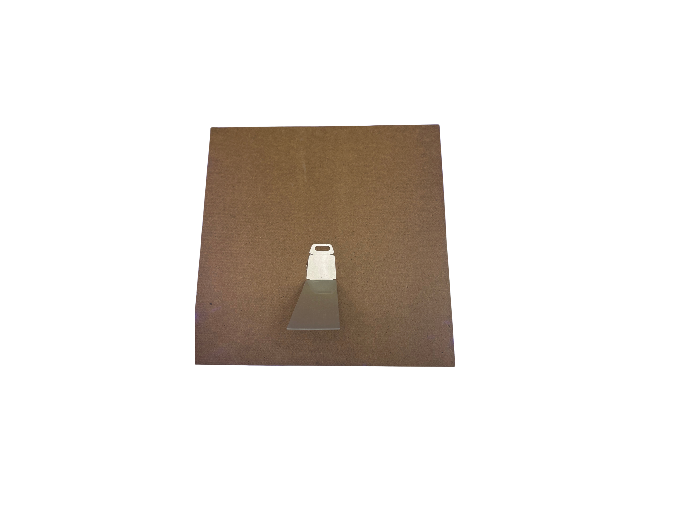 Brown square paper with a silver bell cutout on a white background