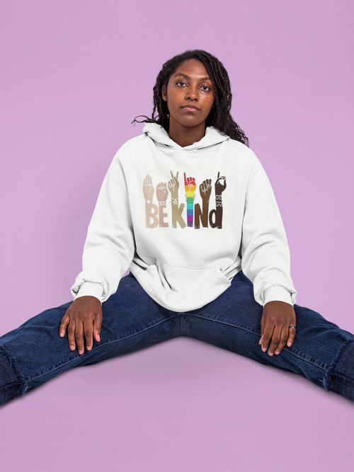 Person wearing a white hoodie with colorful text and symbols on a purple background