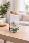 Decorative item with wooden spheres and a turquoise flower on a table in a living room setting.