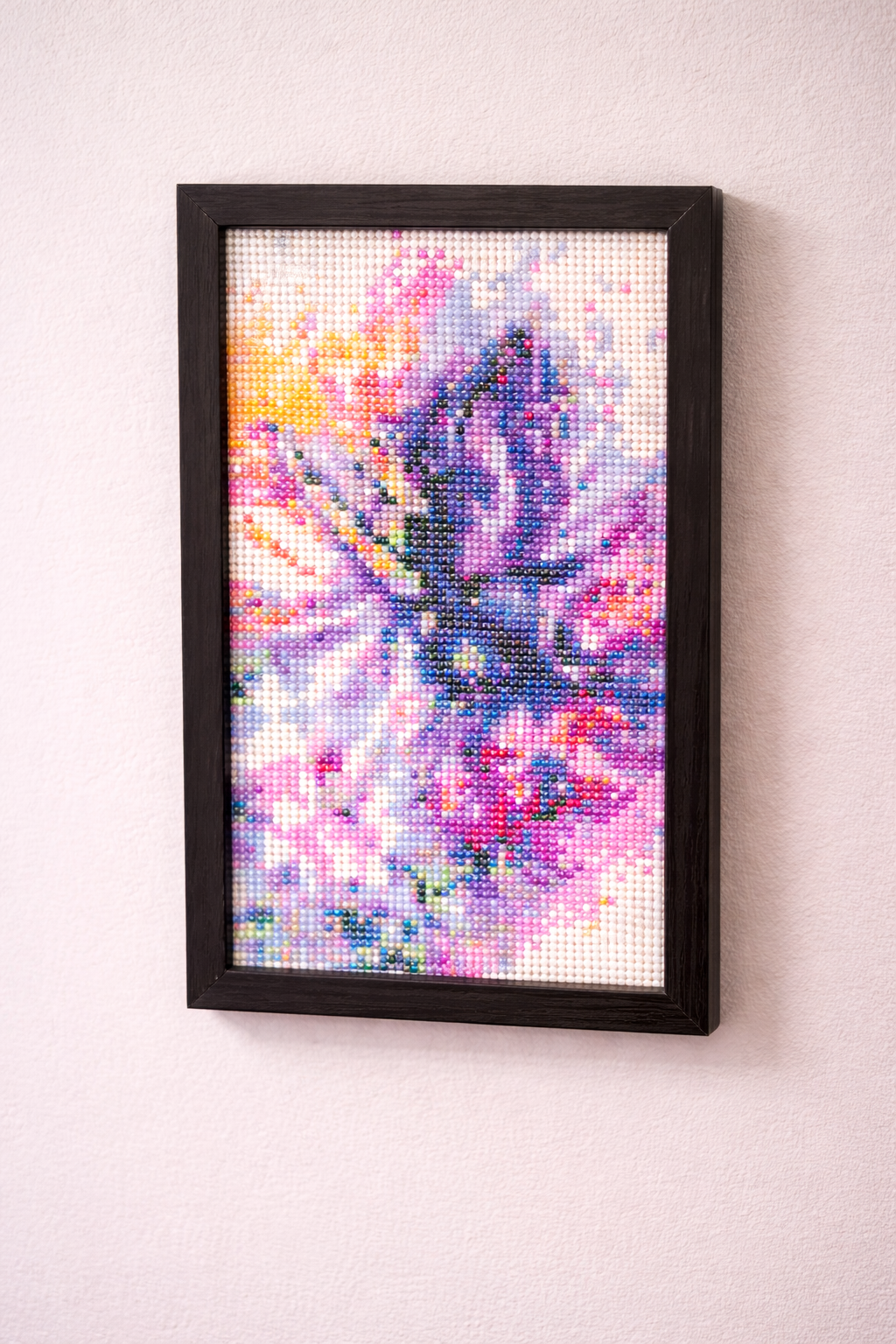 Framed diamond art of a butterfly  on a white wall
