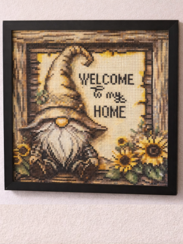 Framed artwork with a gnome and sunflowers and 'Welcome to my Home' text on a light background.