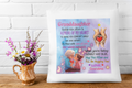 Decorative pillow with a heartwarming message for a granddaughter, placed on a wooden surface with flowers.