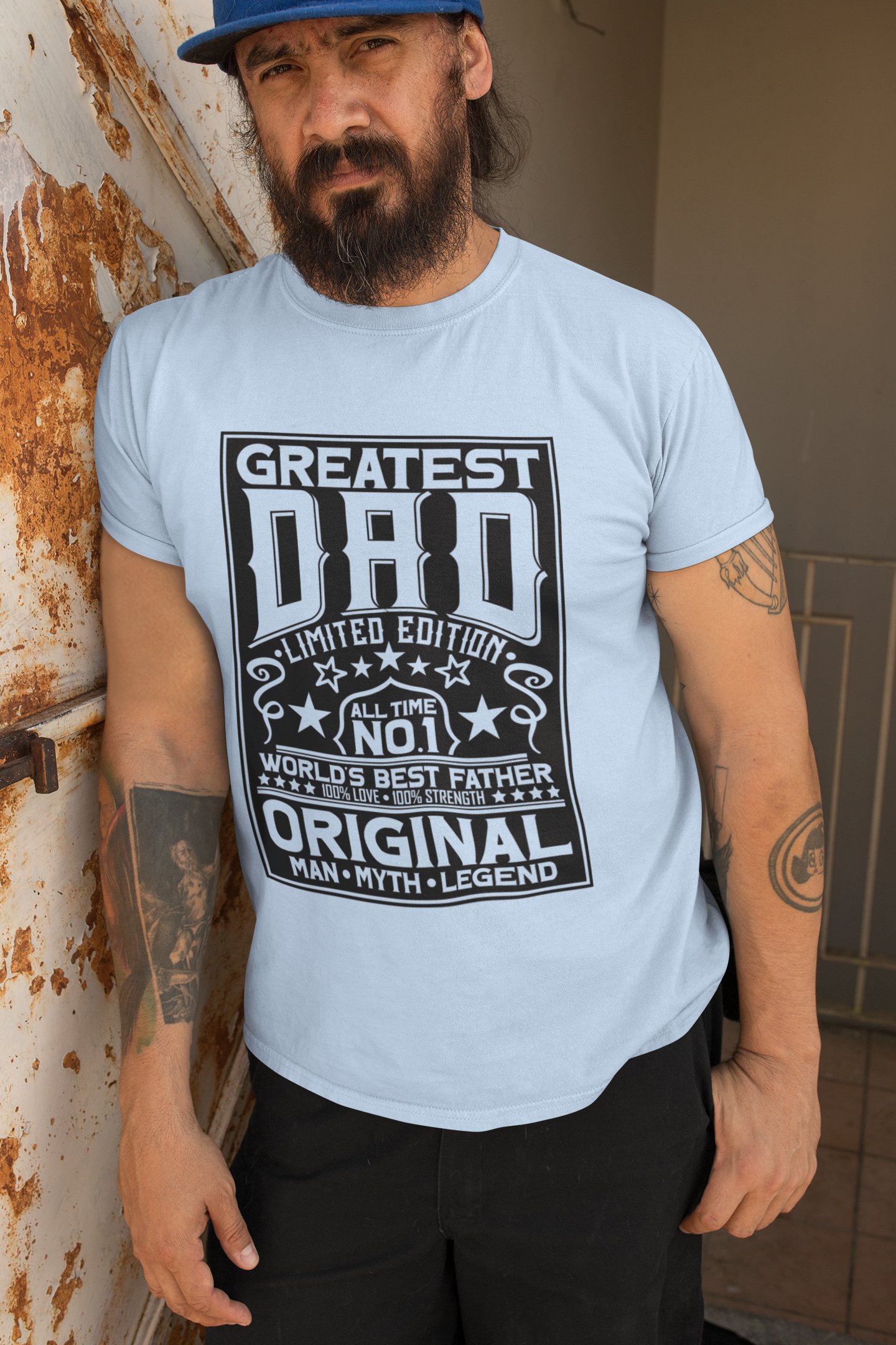 Man wearing a light blue t-shirt with 'Greatest Dad' text design.