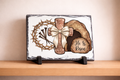 Decorative slate with religious symbols on a wooden shelf