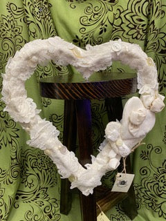 Decorative heart-shaped frame with floral details on a green patterned background