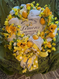 Decorative wreath with lemons, flowers, and a sign on a green background