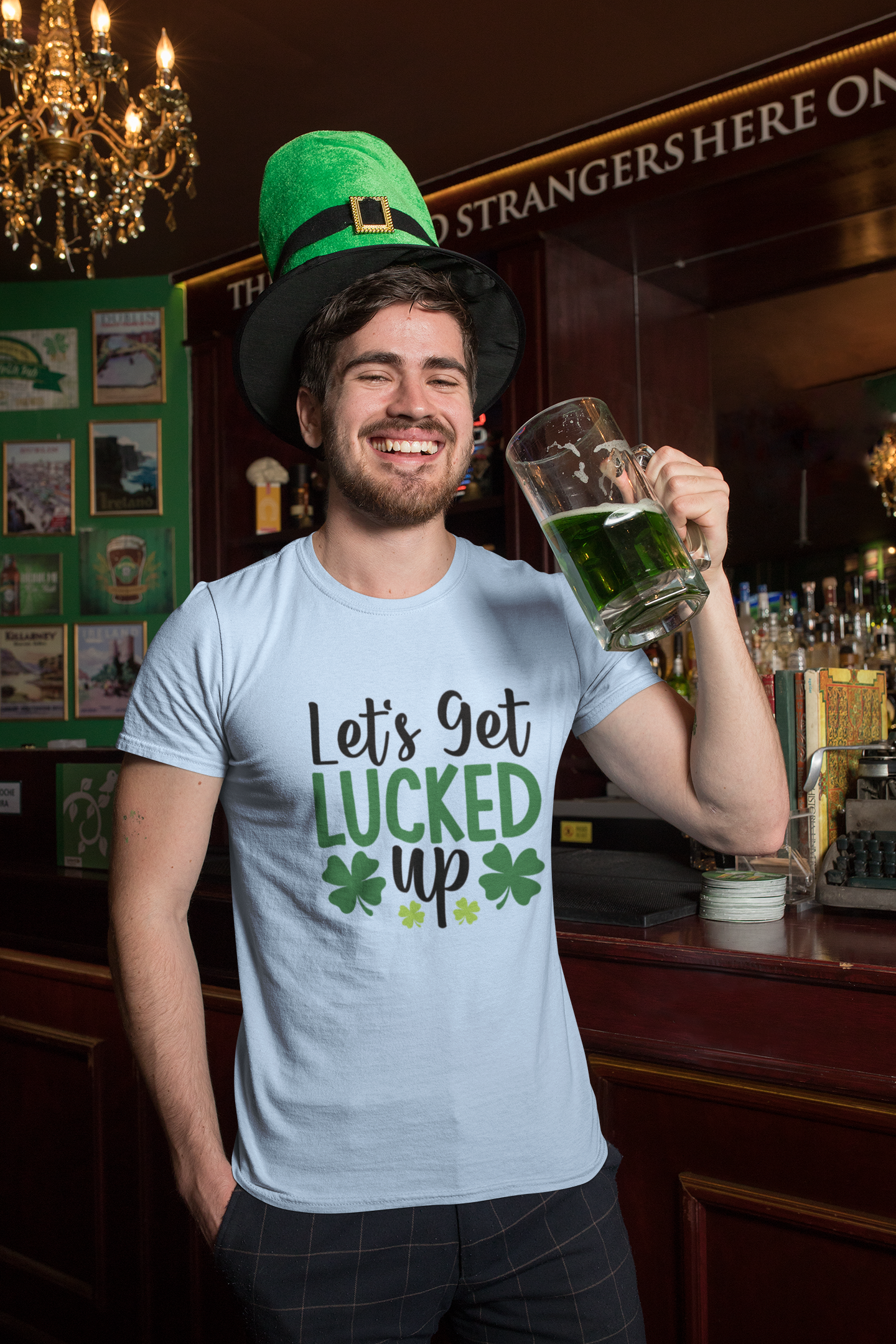 Man wearing a St. Patrick's Day-themed blue shirt and hat, holding a mug of green beer in a bar.
