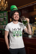 Man in a bar wearing a St. Patrick's Day shirt and green hat, holding a mug of green beer.