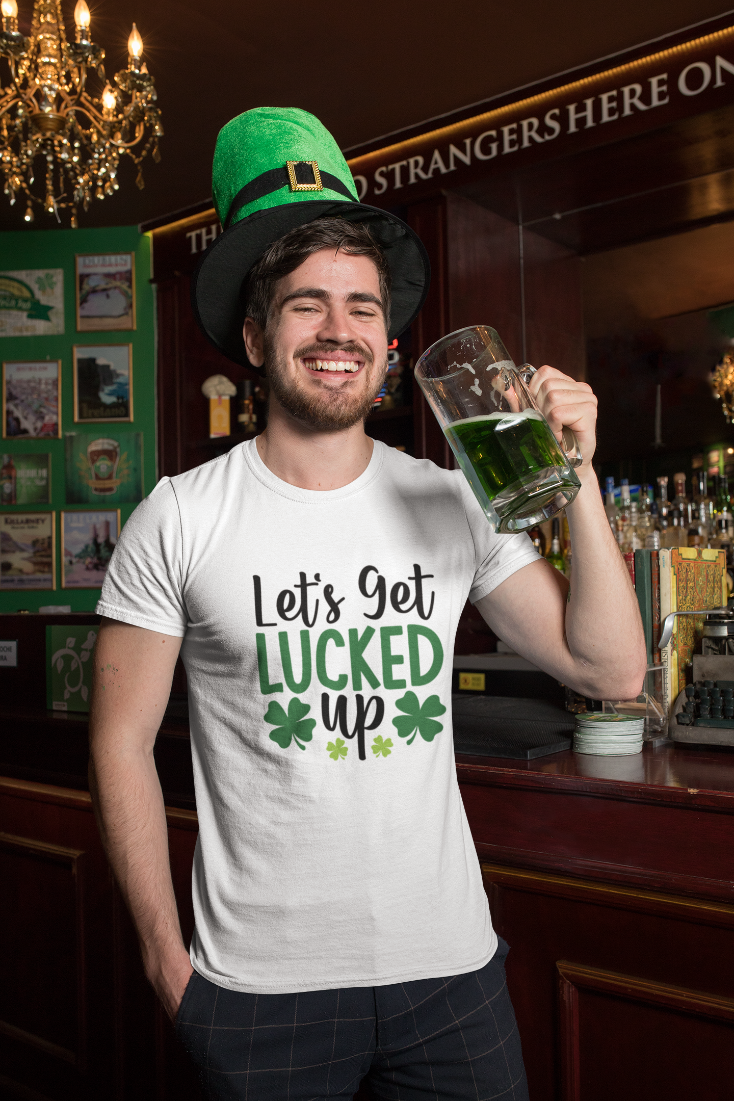 Man in a bar wearing a St. Patrick's Day shirt and green hat, holding a mug of green beer.