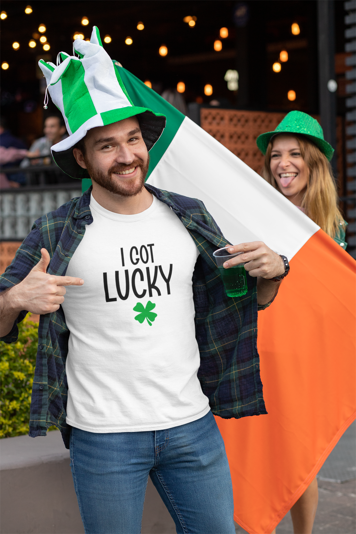 Man wearing a 'I Got Lucky' shirt and Irish flag, with a woman in the background.