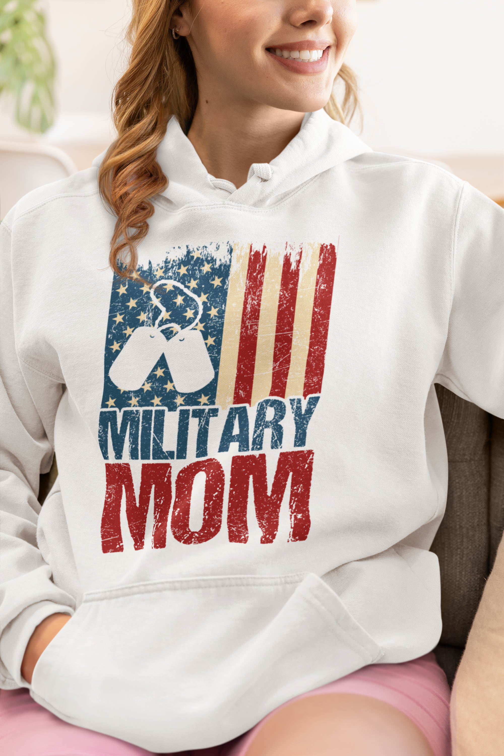 Person wearing a white hoodie with 'Military Mom' design featuring an American flag.