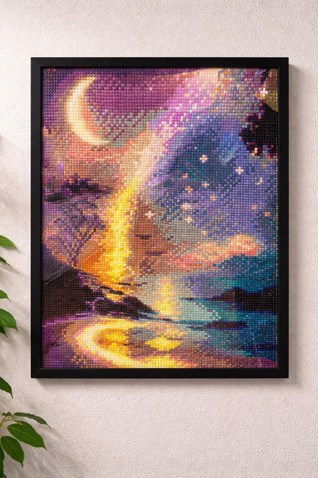 Framed artwork of a celestial scene with a crescent moon and starry sky on a light gray wall.