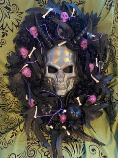 Decorative wreath with skull and candles on a patterned background