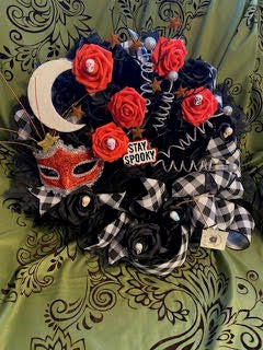 Decorative wreath with Halloween-themed elements on a green fabric background