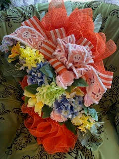 Decorative flower arrangement with ribbons on a patterned fabric background