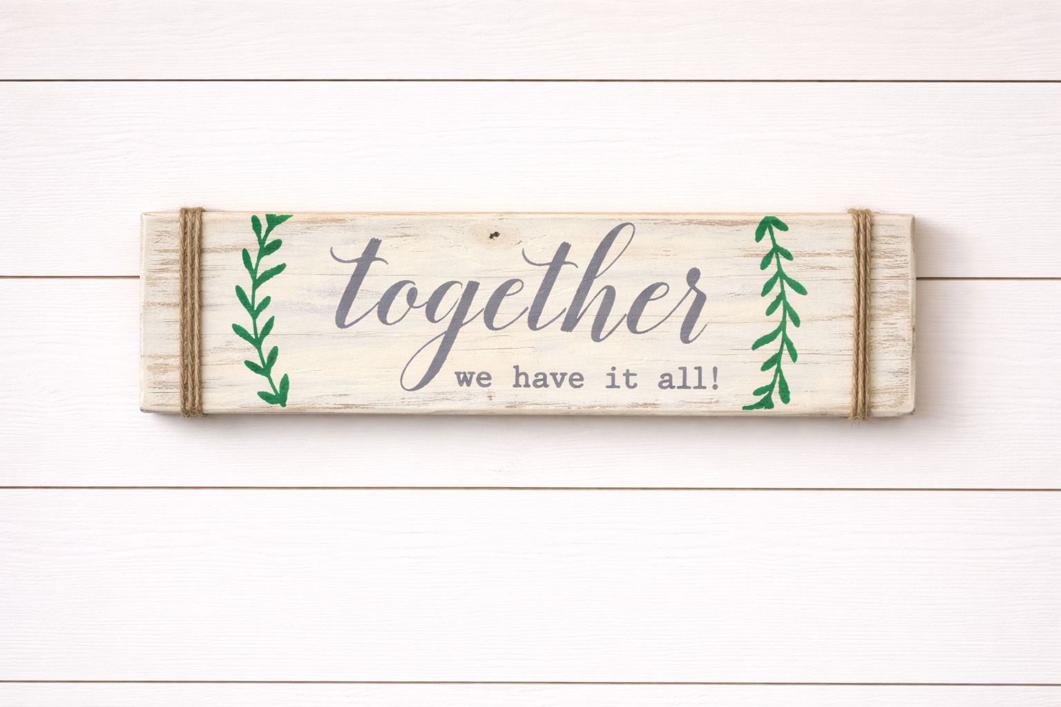 Wooden sign with 'together we have it all' text on a white wooden background