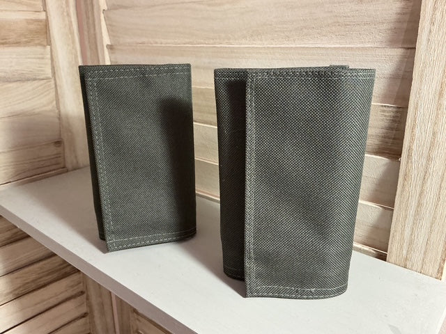 Two gray fabric pouches on a light wooden surface.