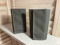 Two gray fabric pouches on a light wooden surface.