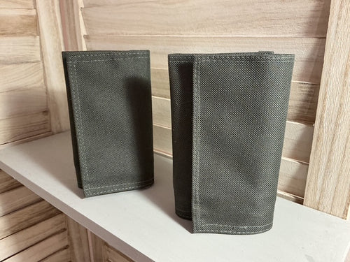 Two gray fabric pouches on a light wooden surface.