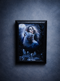 Framed artwork of a woman and a wolf in a snowy landscape on a dark blue textured wall.