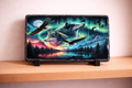 Laptop with a nature-themed design featuring wolves and an eagle on a stand.