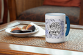 Mug with 'World's Okayest Mom' text on a table with figs