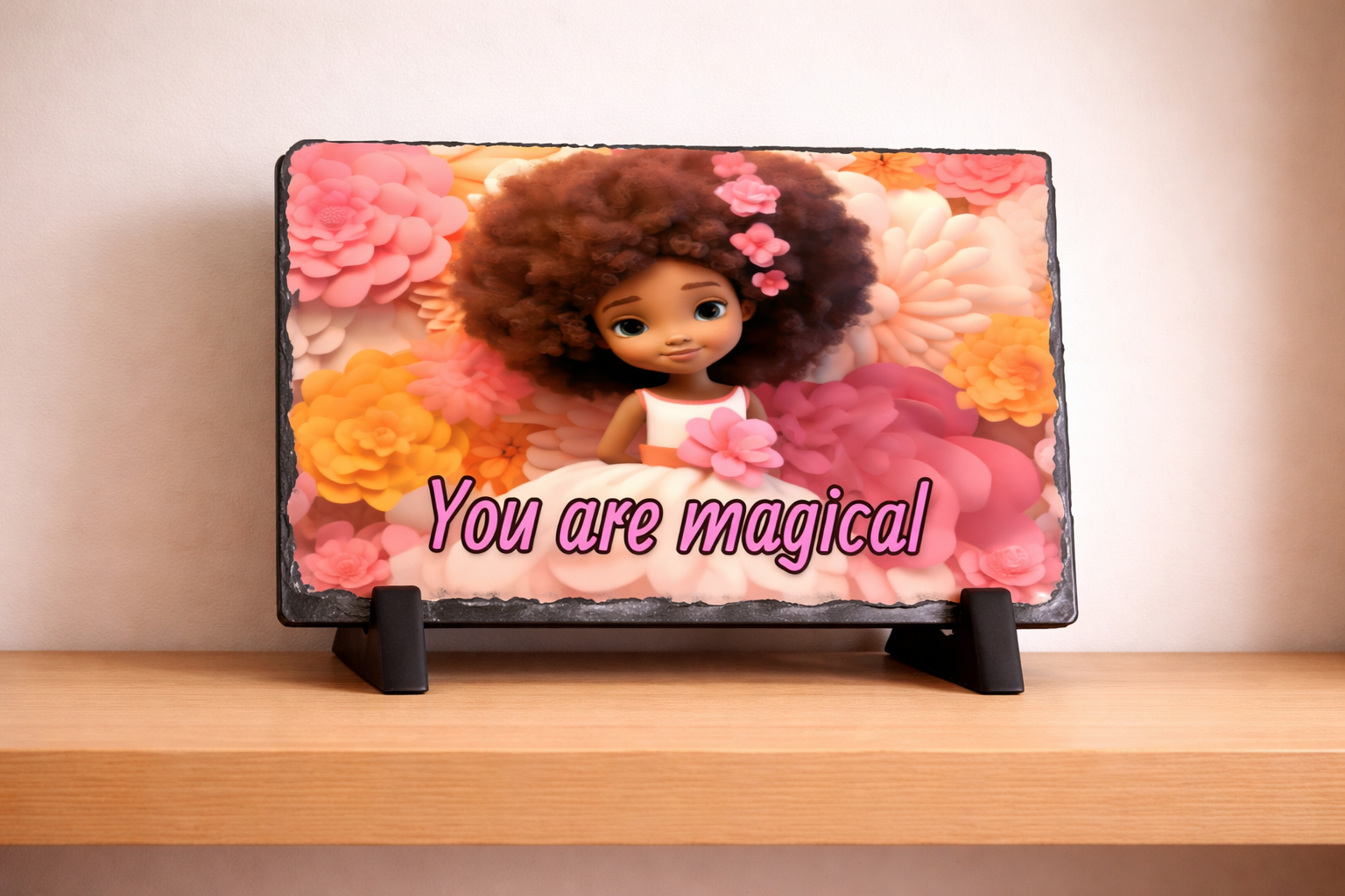 Decorative slate with a doll and floral design on a wooden surface